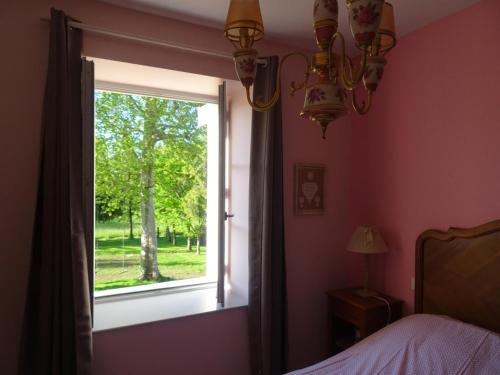 a bedroom with a window looking out at a tree at Maison de caractère à Gy avec parking et Wifi - FR-1-583-448 in Gy