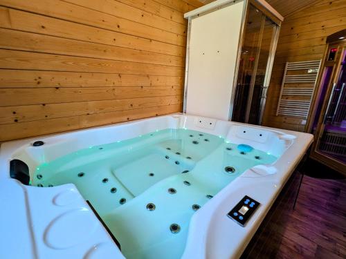 eine Whirlpool-Badewanne in einem Zimmer mit Holzwand in der Unterkunft Chalet détente avec Spa et animaux admis près de Plombières-les-Bains - FR-1-583-498 in La Vaivre