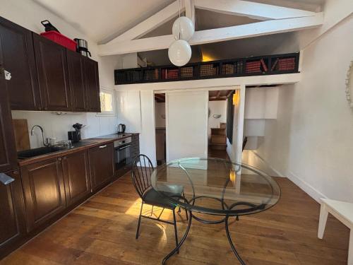 une cuisine avec une table en verre et des chaises. dans l'établissement Charmante maison moderne avec terrasse et parking, cœur de Biarritz - FR-1-239-1132, à Biarritz