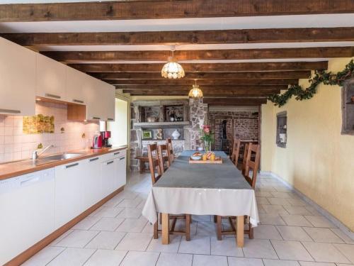 a kitchen with a table and chairs in a room at Ancienne ferme rénovée dans les Vosges - FR-1-583-487 in La Longine