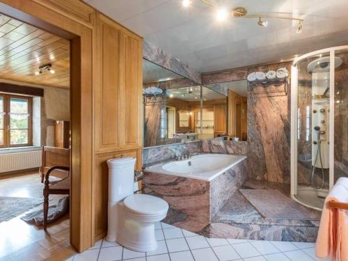a large bathroom with a tub and a toilet at Charme Authentique au Moulin de Saphoz avec Grand Jardin - FR-1-583-499 in Esmoulières