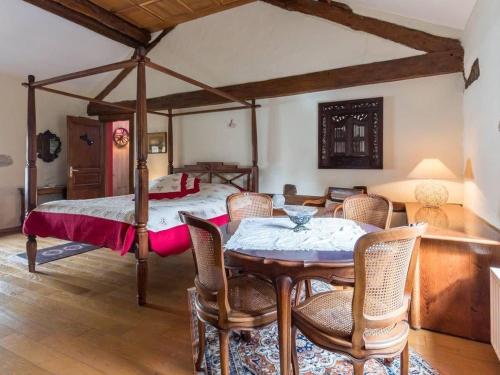 a bedroom with a bed and a table and chairs at Charme Authentique au Moulin de Saphoz avec Grand Jardin - FR-1-583-499 in Esmoulières