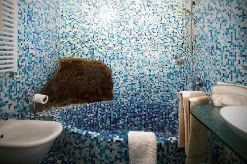 卡莫利的住宿－La Casa di Elisa，蓝色瓷砖浴室设有水槽和卫生间