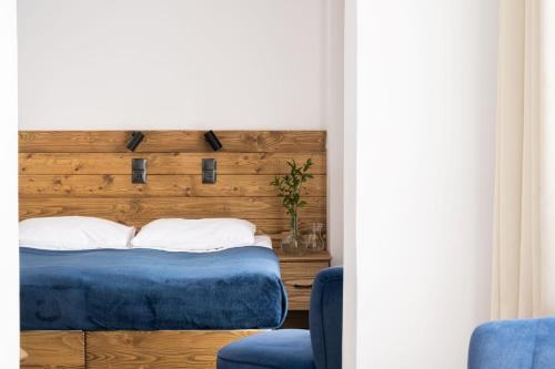 a bedroom with a bed with a wooden headboard at Hotel Rzemieślnik Zakopane in Zakopane