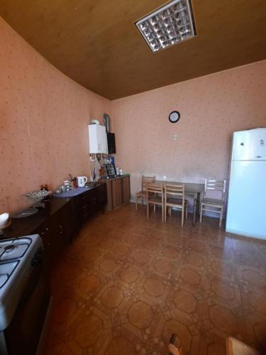 a kitchen with a table and a white refrigerator at Daily rental house in Gori