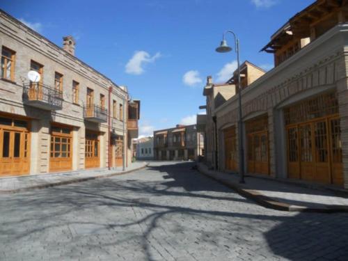 an empty street in an old town with buildings at Daily rental house in Gori