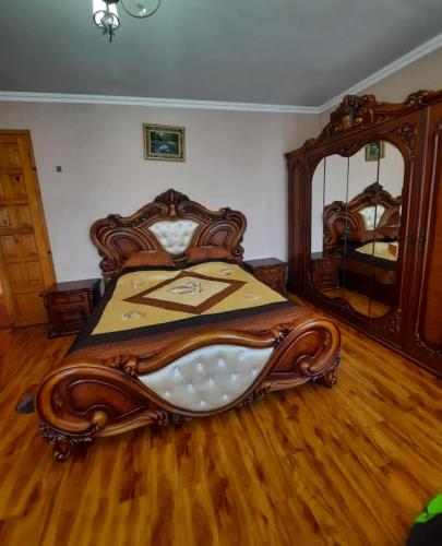 a bedroom with a wooden bed and a large mirror at Daily rental house in Gori