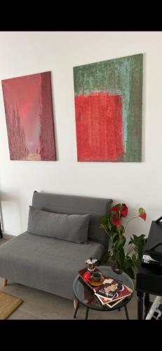 a living room with a couch and two paintings at Thesan B&B in San Prisco