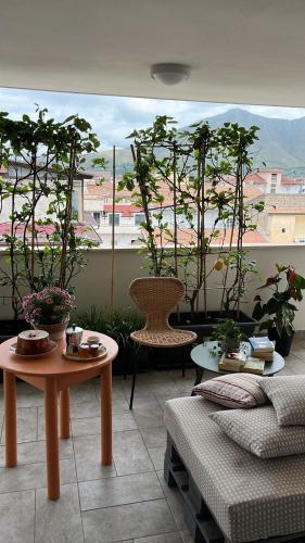 a room with tables and chairs and a large window with trees at Thesan B&B in San Prisco