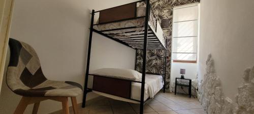 a black bunk bed in a room with a chair at Alloggio Turistico Tedeschi in Santa Maria delle Mole