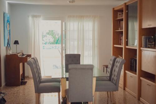 a dining room with a glass table and chairs at Villa Mis 5 Amores con piscina in Benidorm