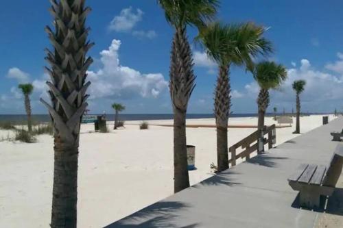 a row of palm trees on the beach at Cheerful 3 bedroom townhome Pool! Beach! Fun! in Gulfport