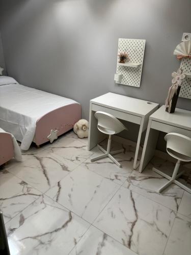 a bedroom with a desk and a bed and marble floor at La pulga en el océano in Torrelavega