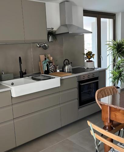 a kitchen with white cabinets and a sink and a table at Thesan B&B in San Prisco