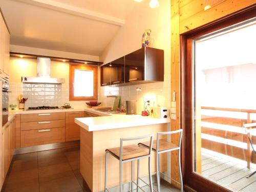 une cuisine avec un comptoir et deux tabourets dans l'établissement Chalet 8 pers, 3 ch + mezzanine, au pied des pistes, WIFI, PARKING - FR-1-572-33, aux Carroz d'Arâches