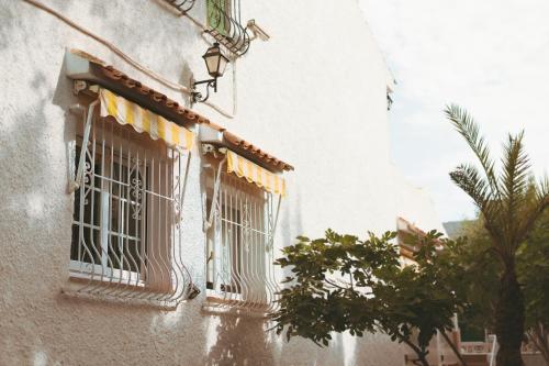 a window with bars on a building in the rain at Villa Mis 5 Amores con piscina in Benidorm