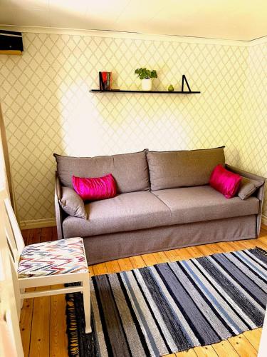 a couch in a living room with pink pillows at Villa Riksberg near Götakanal in Töreboda