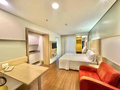 a hotel room with a bed and a table at Flat Nações Unidas SP Limpeza Diária in Sao Paulo