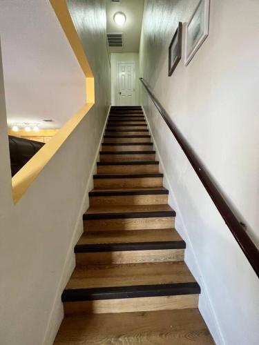 a staircase in a home with wooden floors and white walls at Gorgeous 3 bedroom townhome Walk to the beach in Gulfport