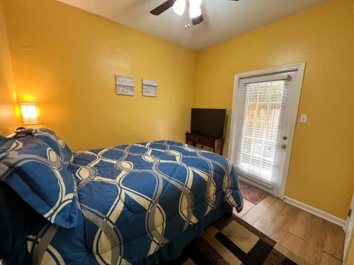 a bedroom with a bed and a window and a television at Gorgeous 3 bedroom townhome Walk to the beach in Gulfport