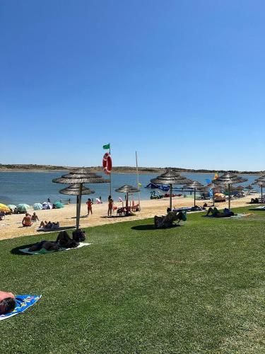 a group of people on a beach with umbrellas at Casa da Vila in Mourão