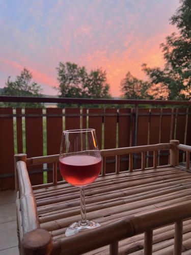 a glass of red wine sitting on a wooden bench at Alte Rose Gasthaus in Ebelsbach