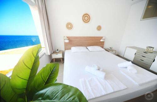 a bedroom with a bed and a view of the ocean at Blue Horizon Apartment in Kalymnos