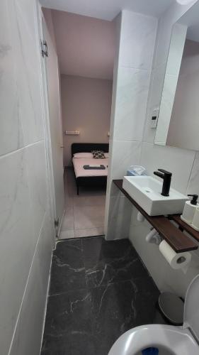 a bathroom with a sink and a bed in a room at Hanapartment 3 bed Ayia NAPA in Ayia Napa