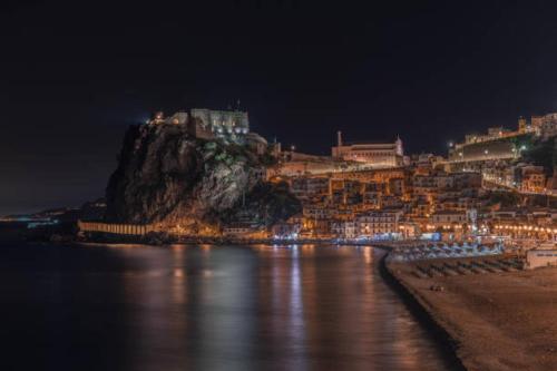 a night view of a town on a mountain at Scilla SeaFront Rooms in Scilla