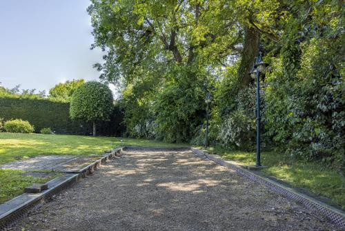 a path in a park with a street light at Villa avec Piscine, Jacuzzi et Sauna Privé dans les Dombes in Ambérieux-en-Dombes