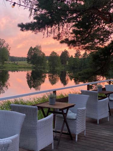 a table and chairs on a deck with a view of a lake at Saarjärve Villa järve ääres 28-le, 8 magamistuba in Tromsi