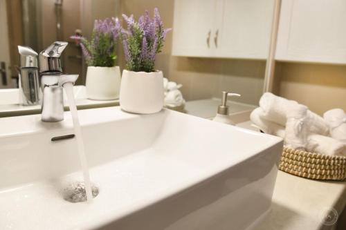 a bathroom sink with flowers in vases on it at Blue Horizon Apartment in Kalymnos
