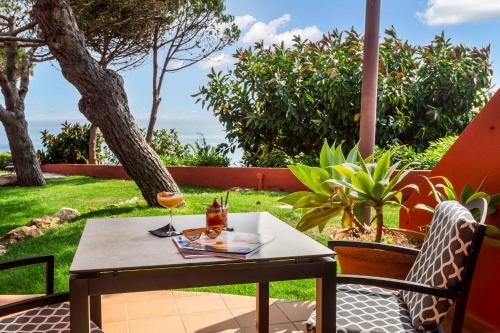 a table with a glass of wine on a patio at Boutique Hotel Vivenda Miranda in Lagos