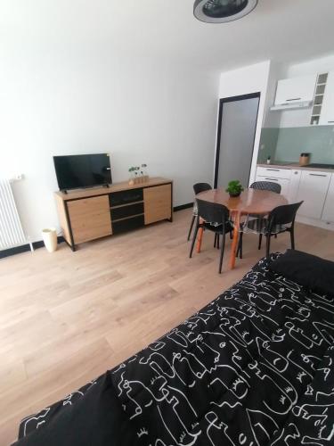 un salon avec une table et une télévision dans l'établissement le miami, à Palavas-les-Flots