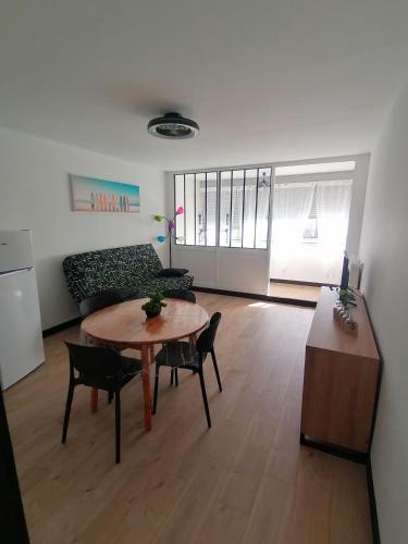 un salon avec une table et un canapé dans l'établissement le miami, à Palavas-les-Flots