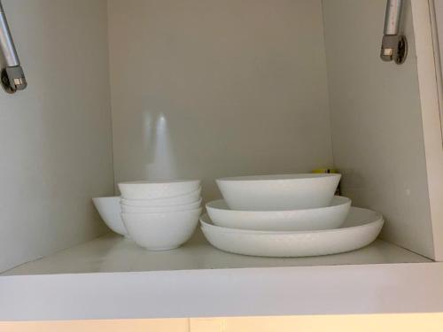 three white bowls sitting on a shelf in a kitchen at ocean vista gio bien in Ấp Phú Tịnh (2)