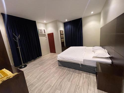 a bedroom with a bed and a wooden floor at N Alharbi Serviced apartments in AlUla