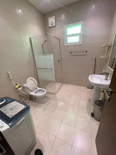 a bathroom with a toilet and a shower and a sink at N Alharbi Serviced apartments in AlUla