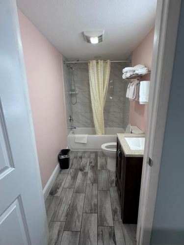 a bathroom with a tub and a toilet and a sink at Atlantic Shores Motel in Daytona Beach