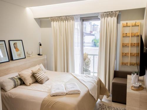 a bedroom with a bed with two towels on it at Joy Tower by FMA Coliving in Salta