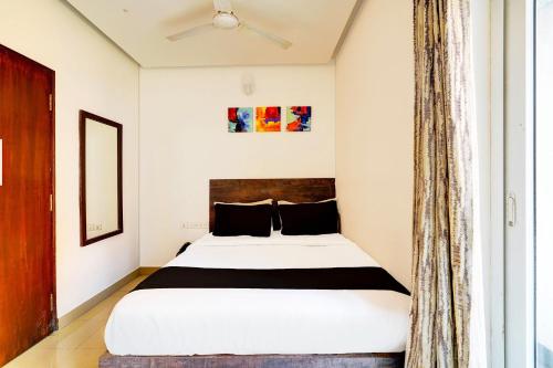 a bedroom with a bed and a window at Super Townhouse Hebbal Bhadrappa Layout in Bengaluru