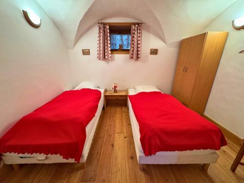 - 2 lits dans une petite chambre avec des draps rouges dans l'établissement Charmant 3P à 4km des pistes avec Wifi à Saint-Martin-de-Belleville - FR-1-452-388, à Saint-Martin-de-Belleville