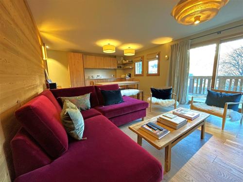 un salon avec un canapé rouge et une table dans l'établissement Appartement 4P 8 Pers avec Cheminée et Parking à Saint-Martin-de-Belleville - FR-1-452-377, à Saint-Martin-de-Belleville