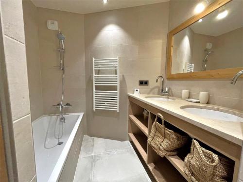 une salle de bain avec une baignoire, un lavabo et un miroir dans l'établissement Appartement 4P 8 Pers avec Cheminée et Parking à Saint-Martin-de-Belleville - FR-1-452-377, à Saint-Martin-de-Belleville