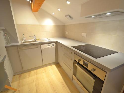 une petite cuisine avec un évier et une cuisinière dans l'établissement Charmant appartement 3 pièces avec parking et wifi à Saint-Martin-de-Belleville - FR-1-452-351, à Saint-Martin-de-Belleville