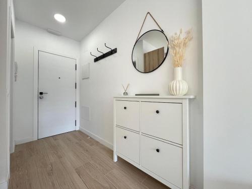 a white dressing room with a mirror and a dresser at Accommodation near the airport in Madrid