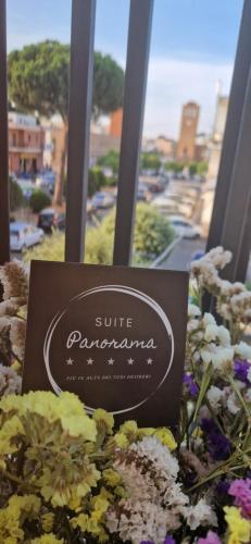 a sign in a bunch of flowers in a window at Suite Panorama in Marconia
