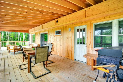 a wooden patio with a table and chairs on a deck at Expansive Wilmot Escape with Deck Near Skiing! in Wilmot