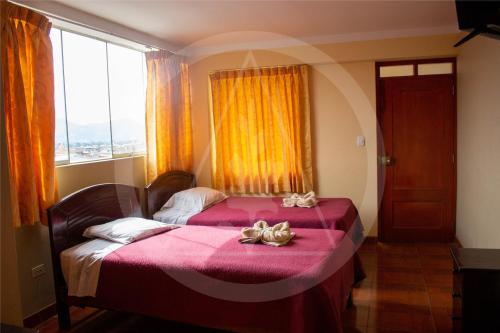 a bedroom with a bed with pink sheets and a window at Retamas Hotel 2 in Cajamarca
