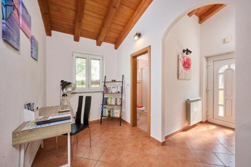 a home office with a desk and a book shelf at Casa di Oliva in Brtonigla